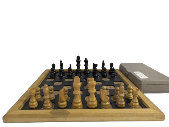 The image shows a chess set designed for blind players. The chessboard has a wooden frame and the squares are raised, likely to help players feel the board. The chess pieces are in two colors, light and dark, and are placed on the board. Next to the chessboard, there is a closed box,for storing the pieces